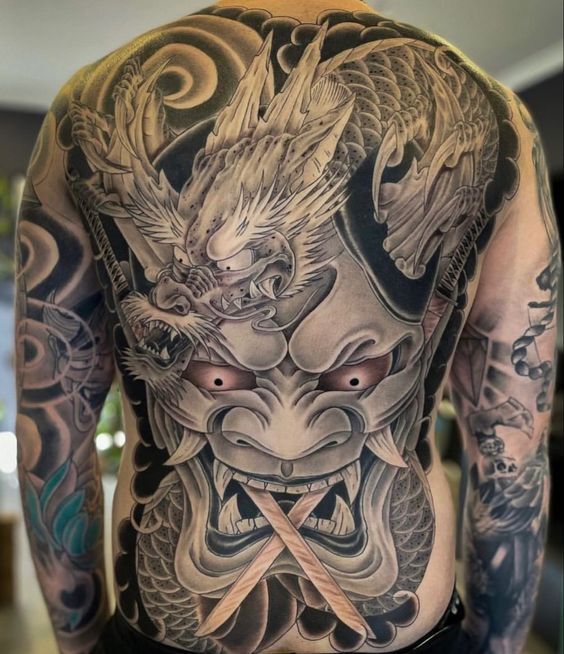 Hình xăm rồng kết hợp họa tiết mặt quỷ cầm hai thanh kiếm che lưng tattoo rồng kết hợp họa tiết mặt quỷ ngậm song kiếm bít lưng