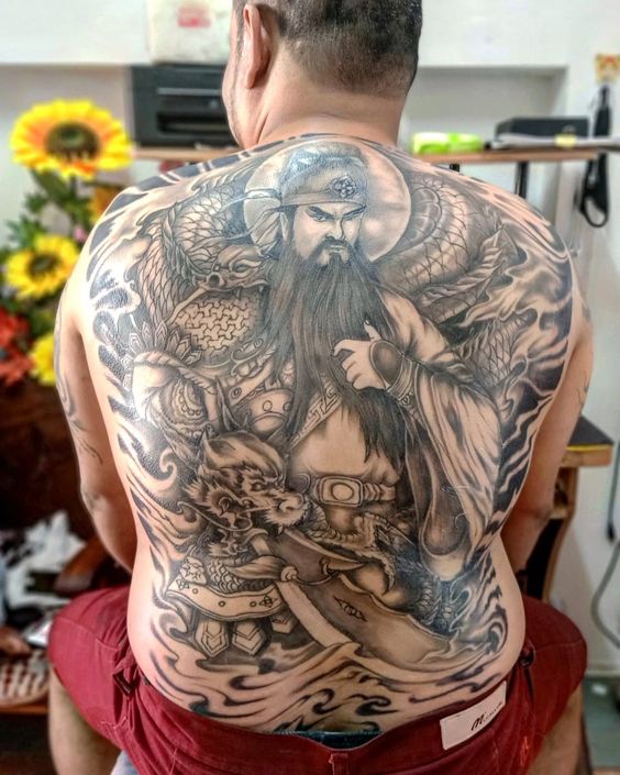 Khách hàng xăm hình quan cầm con rồng đơn sắc, ngáp dài và con dao mặt trăng che lưng anh khách xăm hình của quan vũ cầm thanh long yển nguyệt đao đơn sắc kín lưng