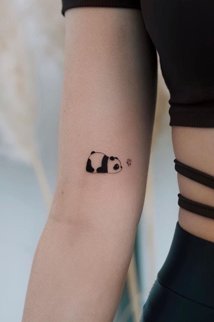Hình xăm chú gấu trúc nhỏ buồn ngủ trên bắp tay của phụ nữ xăm gấu trúc mini buồn ngủ ở bắp tay nữ